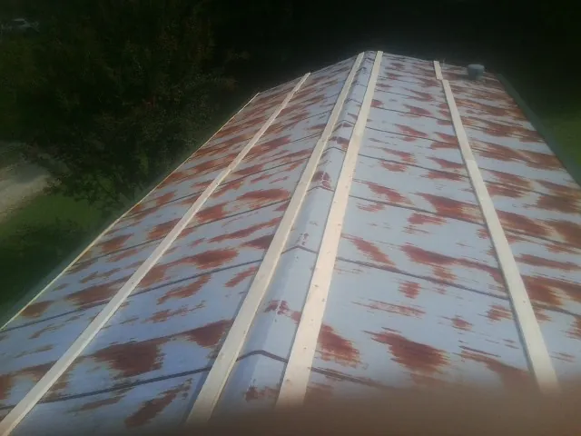Rusted metal roof panels with new wood purlins before replacement — Storm Damage Roof Repair in Gratiot by Roofing Brothers