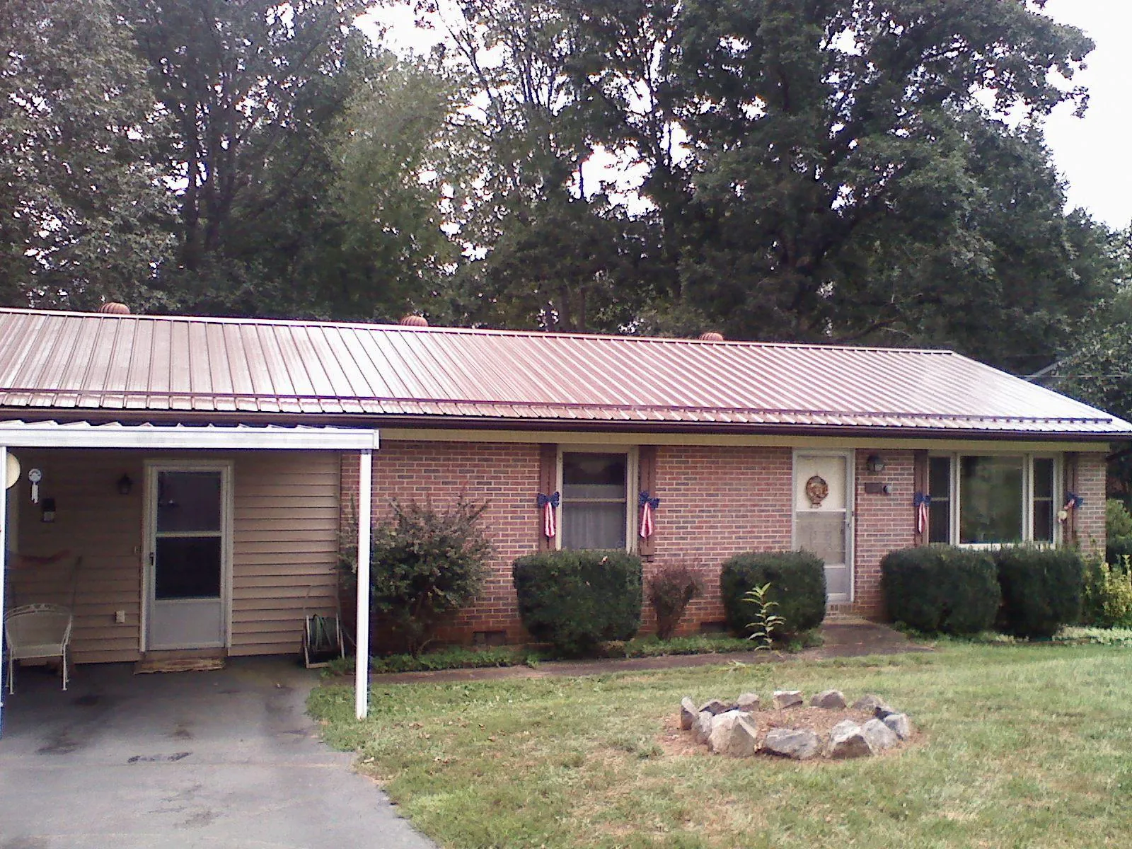 Bronze metal roof and carport on a brick ranch home — Roof Repair work by our crew in Gratiot